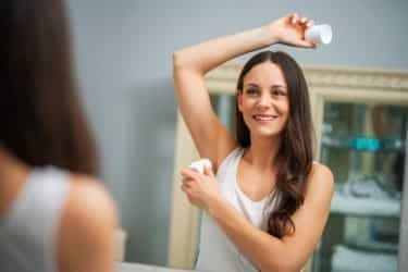 young girl applying underarm deodorant