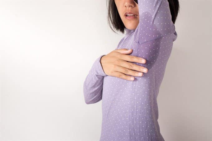 woman with sweaty arm pits showing on sweater