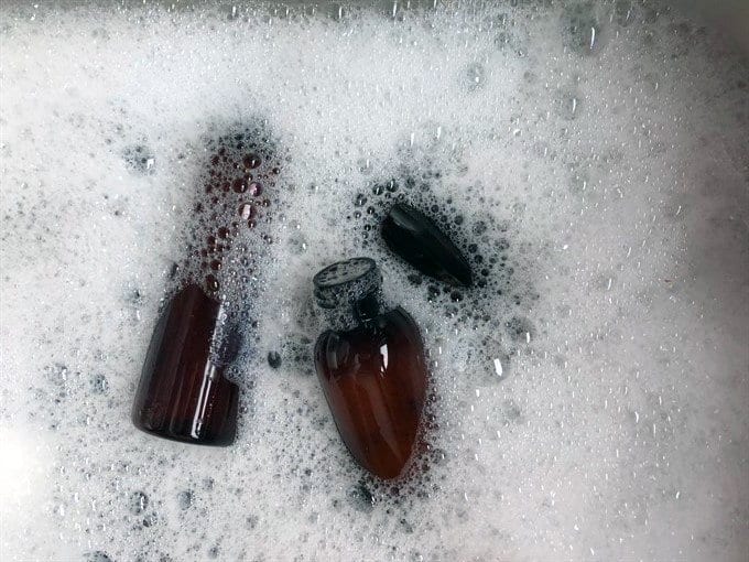 soaking essential oil bottles for reuse in soap