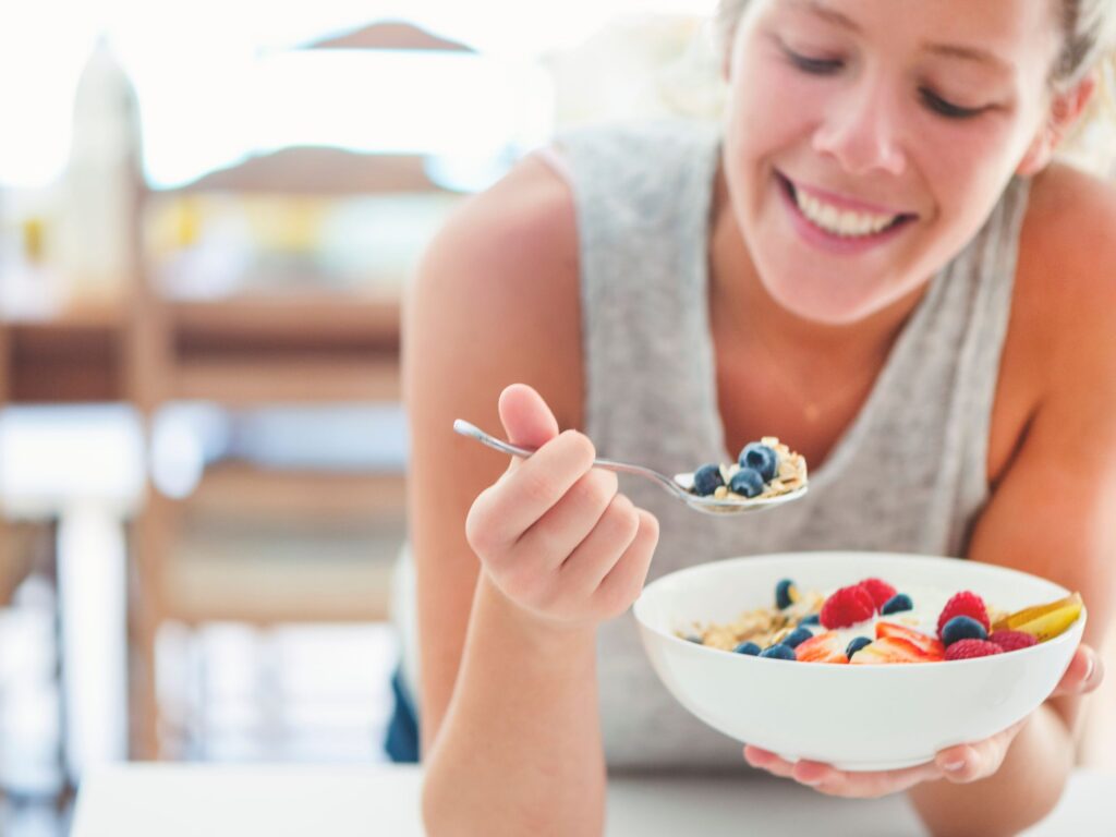 woman eating a bowl of healthy cereal